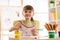 Cute preschooler child girl drawing with pencils in nursery