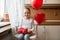 Cute preschooler girl celebrating 6th birthday. Girl holding her birthday cupcake and beautifully wrapped present.