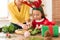 Cute preschooler girl wearing reindeer antlers and her mother making christmas wreath in living room. Christmas family fun.