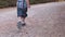 Cute preschooler in short jeans and colorful shirt running in park. Low angle slow motion