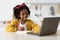Cute Preteen Black Girl Writing In Notepad While Study Online With Laptop