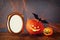 Cute pumpkin next to blank photo frame on wooden table