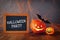 Cute pumpkins next to blackboard on wooden table