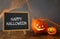 Cute pumpkins next to blackboard on wooden table