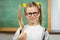 Cute pupil doing thumbs up in a classroom