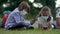 Cute pupils using smartphones at the elementary school. Boy and girl in safety masks with gadgets in their hands.