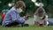 Cute pupils using smartphones at the elementary school. Boy and girl in safety masks with gadgets in their hands.