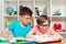 Cute pupils writing at desk in classroom. Education, elementary school. Student doing test in primary school