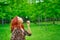 Cute red-haired woman blows away a dandelion.