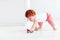 Cute redhead baby boy rolling a toy car on the floor