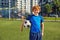 Cute redhead boy child wearing sportive uniform with soccer ball portrait