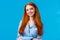 Cute redhead caucasian girl in blue nightwear prepare sleep, brushing hair, apply night cosmetics, smiling joyfully