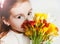 Cute redhead girl smelling spring flowers freesia. close up