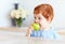 Cute redhead toddler baby biting tasty green apple