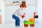 Cute redhead toddler baby collecting different balls into toy pushcart