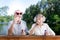 Cute retired couple wearing bright sunglasses using soap bubbles