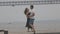 A cute romantic married couple dancing on the pier in cloudy weather