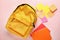 Cute rucksack with school stationery on color background