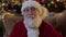 Cute Santa Claus looks at camera operator and smiles cheerfully. Portrait kind smiling Santa Claus with gray beard in