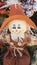 Cute scarecrow doll with large orange hat smiling