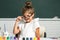 Cute school girl face with glasses. Little girls drawing a colorful pictures with pencil crayons in school classroom