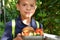 Cute schoolboy eating outdoors the school from plastick lunch boxe. Healthy school breakfast for child. Food for lunch