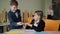 Cute schoolboy giving pencil to pretty schoolgirl and smiling. Portrait of charming Caucasian children studying in