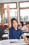 Cute Schoolboy Raising Hand In Classroom