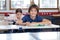 Cute Schoolboy Sitting In Classroom