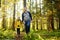 Cute schoolchild and his mature father hiking together and exploring nature. Little boy with his dad spend quality family time