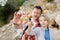 Cute schoolchild and his mature father hiking together on mountain and exploring nature. Dad and son spend quality time together.