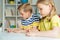 Cute schoolchildren are came back to school and learning at the table in classroom