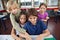 Cute Schoolchildren Using Laptop At Desk