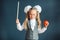 Cute schoolgirl with glasses and red Apple in hand looking like a strict teacher raised her pointer to draw attention. Educational