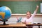 Cute schoolgirl raising her hand to answer a question