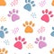 Cute seamless pattern with colorful pets paws. Cat or dog footprint outline bright background with dots