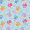 Cute seamless pattern with colorful pets paws on light blue. Cat or dog footprint outline background with dots. Animal backdrop