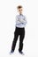 Cute serious boy a schoolboy of 8 years in a blue shirt and trousers stands with his arms crossed on his chest. Full height. White