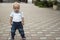 Cute serious toddler posing in blue jeans and white t-shirt and looking ahead. Copy space