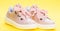 Cute shoes on yellow background. Footwear for girls or women decorated with pearl beads. Pair of pale pink female