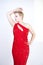 A cute short hair plus size girl with a curvy figure stands in a red long tight sequin dress with a teardrop neckline on her chest