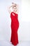 A cute short hair plus size girl with a curvy figure stands in a red long tight sequin dress with a teardrop neckline on her chest