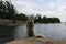 Cute siberian husky is sitting outside beside cottage chairs overlooking lake huron