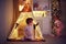 Cute siblings, babies in pajamas playing in teepee tent at home in the evening on Christmas holidays