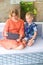 Cute siblings brother and sister sitting on sofa at home and playing on wireless tablet together