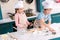 cute siblings in chef hats and aprons preparing cookies together