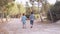 Cute siblings , holding hands and walking in the park. Back view slow motion. Toddler looking back