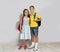 The cute siblings with school bags , gray background