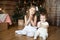 Cute sisters in front of decorated Christmas tree