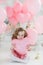 Cute six year old girl in pink dress with pink balloons in the shape of heart